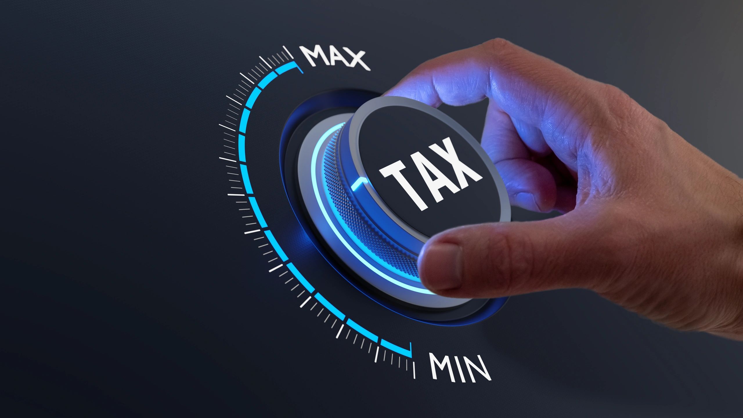 Hand turning a glowing blue dial labeled “TAX” from MIN to MAX—ideal for NYC CPAs Tax Planning