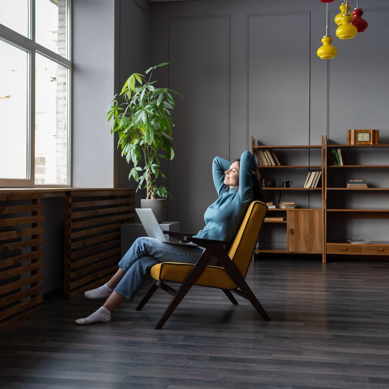 Happy female remote worker resting with closed eyes from computer screen, relaxing and recovering after long working day at cozy home office. Self-employed mental wellbeing, freelance productivity
