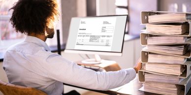 Professional at a desk managing digital invoices and organized binders to transform financial chaos 