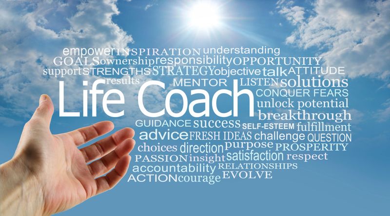 hand gesturing towards a LIFE COACH word cloud against a blue sky sunburst and fluffy clouds background