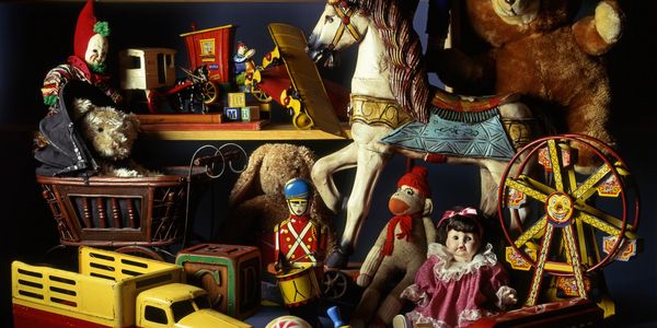 A collection of vintage toys including a rocking horse, teddy bear, clown, and toy train.