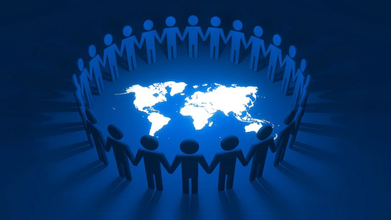 Group of cutout people holding hands together forming a connected circle of alliance and cooperation around white world map on blue background. 3D illustration concept of community and togetherness.