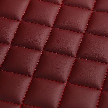 Close-up of red quilted leather with matching red stitching.