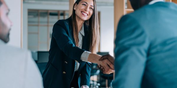 Two professionals shaking hands in an office.