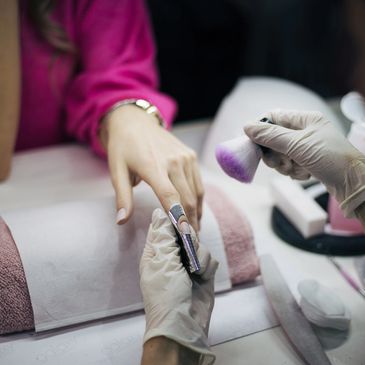 Manicure in progress with nail polish application and hand care.