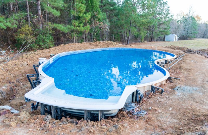 New swimming pool being installed in a back yard