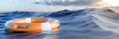 Orange lifebuoy floating on ocean water.