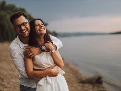 Relationship coaching and hypnotherapy for couples. A happy couple embracing on a beach. Improving communication in relationships.