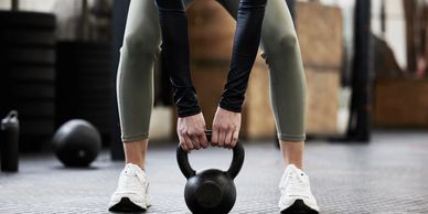 An occupational therapy client engaging in a weighted squat, representing work conditioning services