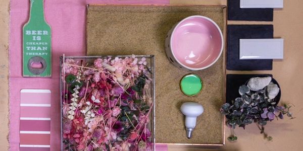 Pink-themed flat lay with dried flowers, a pink bowl, and green bottle opener.