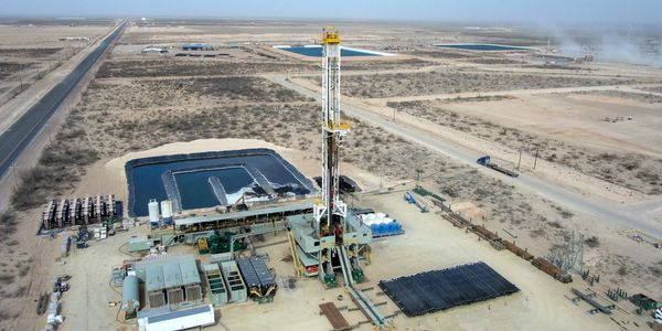 Oil drilling rig in desert landscape.