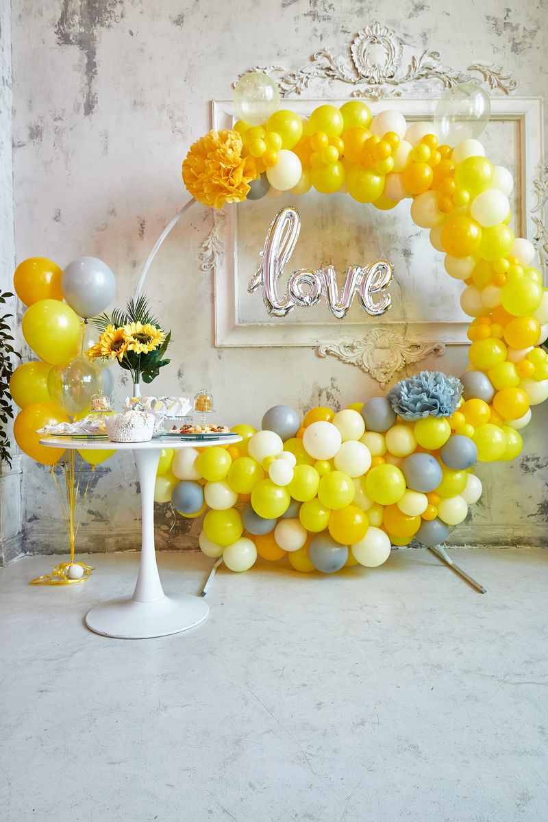 Photo zone of yellow and gray balloons. The party is decorated with balloons. Vertical image.