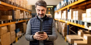 Man using phone in warehouse.
