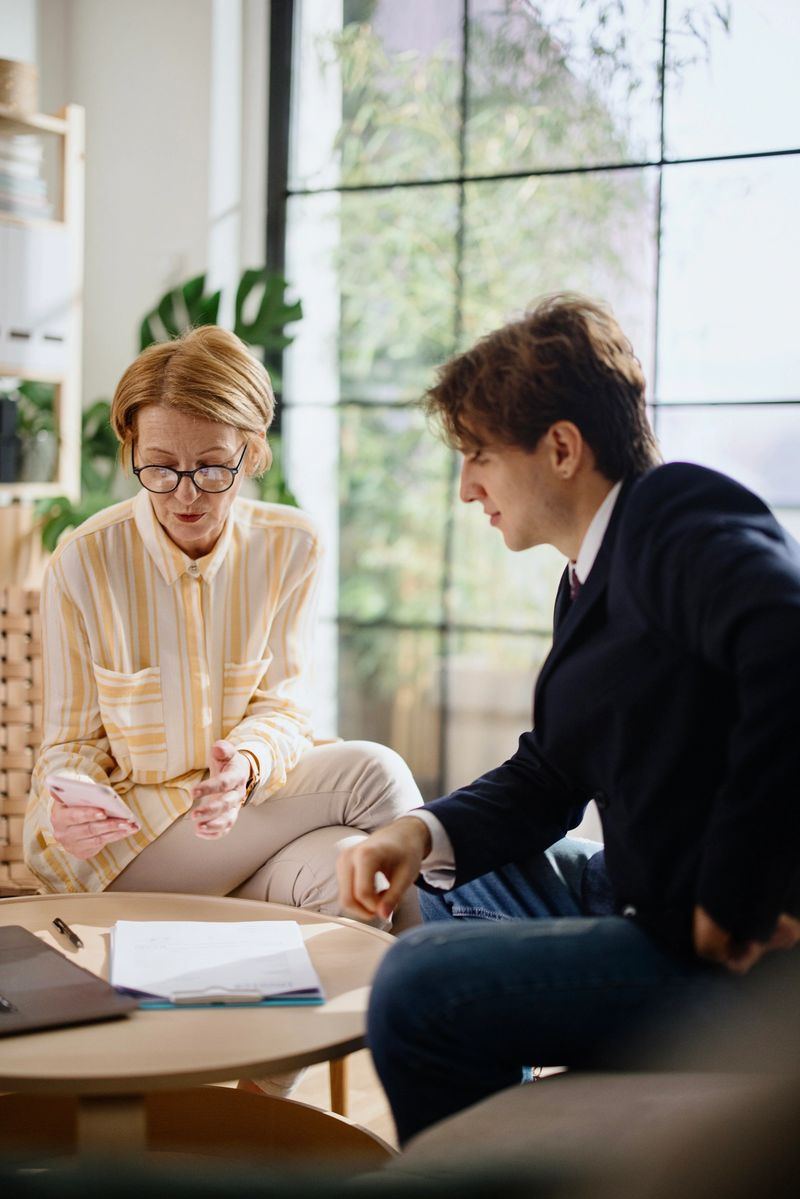 Mature woman meeting with a financial consultant to discuss paperwork at home