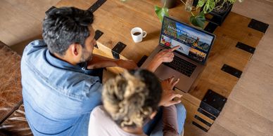 Two people planning a trip on a laptop.