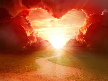 Sunset with heart-shaped clouds and a winding path through a field.