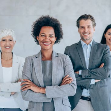 Confident diverse business team smiling with arms crossed.