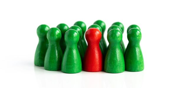 Red game piece stands out among green pieces on white background.
