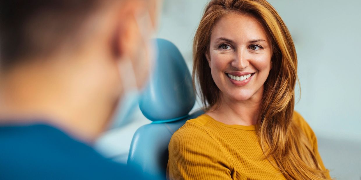 A woman smiling at a healthcare professional during a consultation.