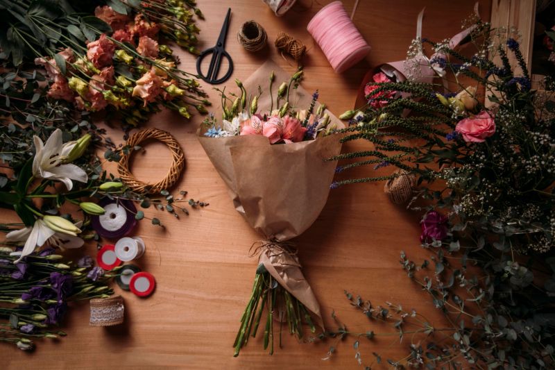 Bouquet and flower arrangement sitting on a wooden table