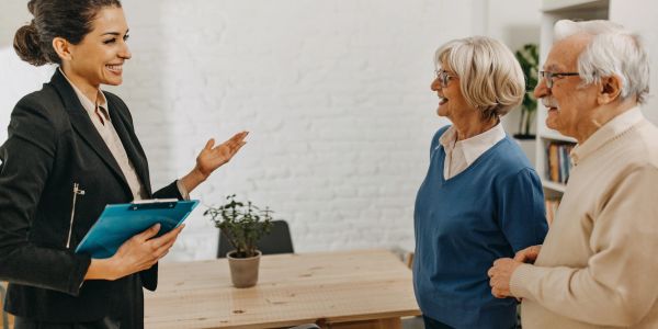 Real estate agent talking to elderly couple in home office.