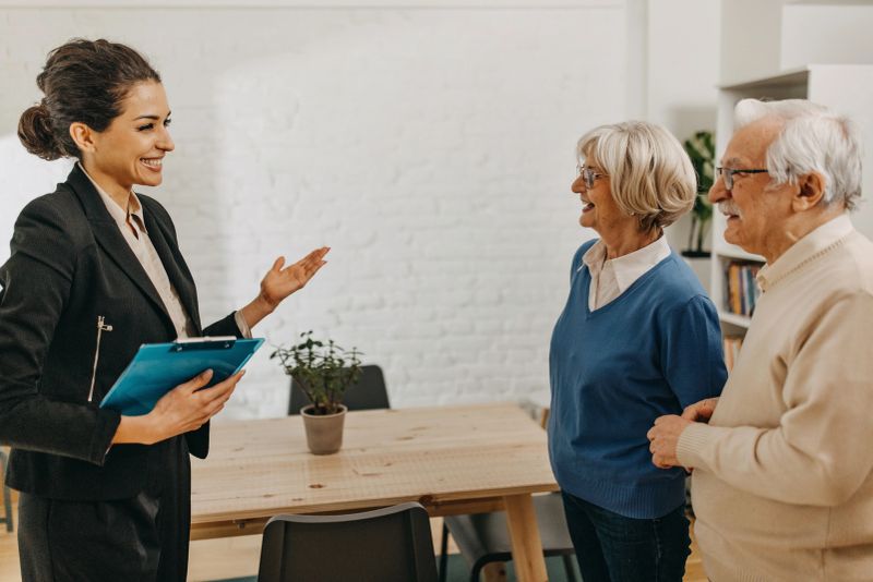 Senior couple consults with female real estate  agent