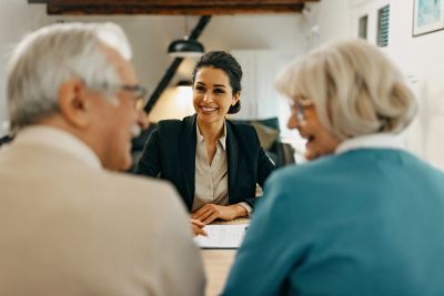 Smiling advisor meeting with elderly couple.