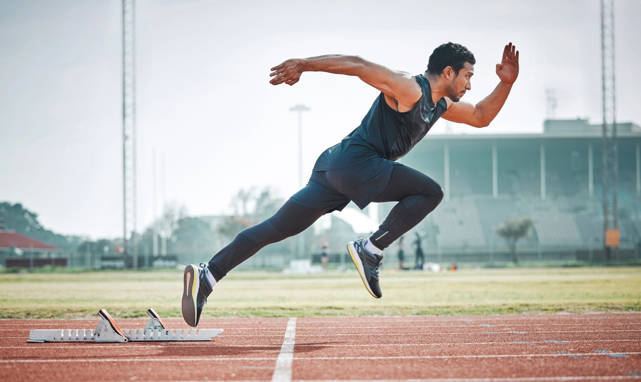 Athlete sprinting on a track during a race start.