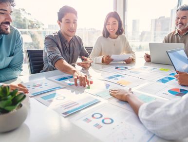 Team discussing graphs and charts in a bright office.