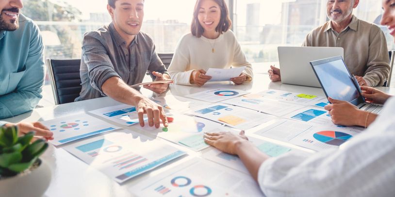 Team discussing business charts and graphs in a meeting.