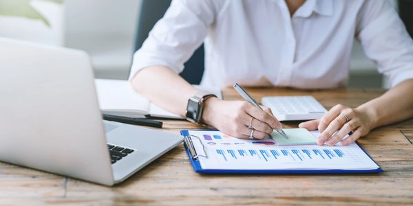 Healthcare professional documenting medical billing information on clipboard in medical practice. 