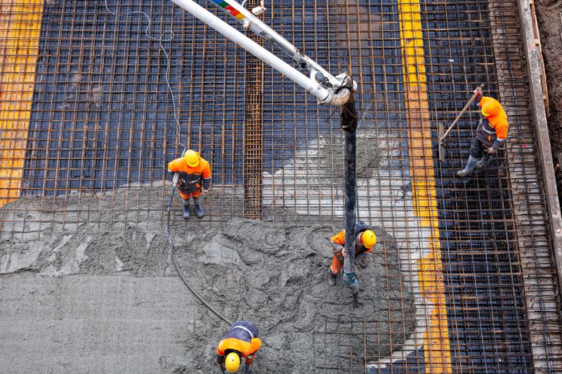 Workers pouring concrete. Concrete pouring on the construction site. Concrete pump. Reinforcement steel, reinforcing bar, rebar, foundation plate.