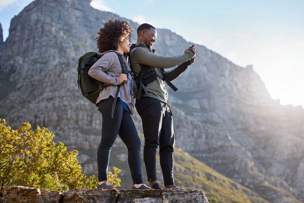Couple hiking outdoors, enjoying scenic mountain views.