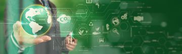 Businessman holding a glowing globe with digital environmental icons.