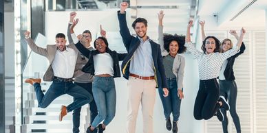 A group of people is cheering and raising their arms.
