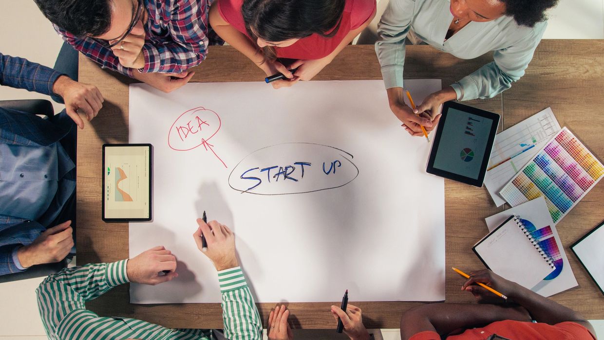 Team brainstorming startup ideas around a table.
