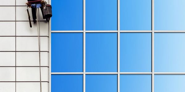 Window cleaner working on tall building facade.