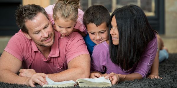 Family lying on the floor, enjoying time together.