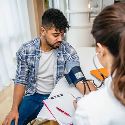 A man has his blood pressure checked by a healthcare professional.