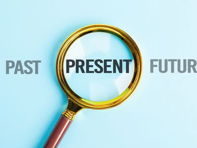 the words past, present and future with a magnifying glass over the word present