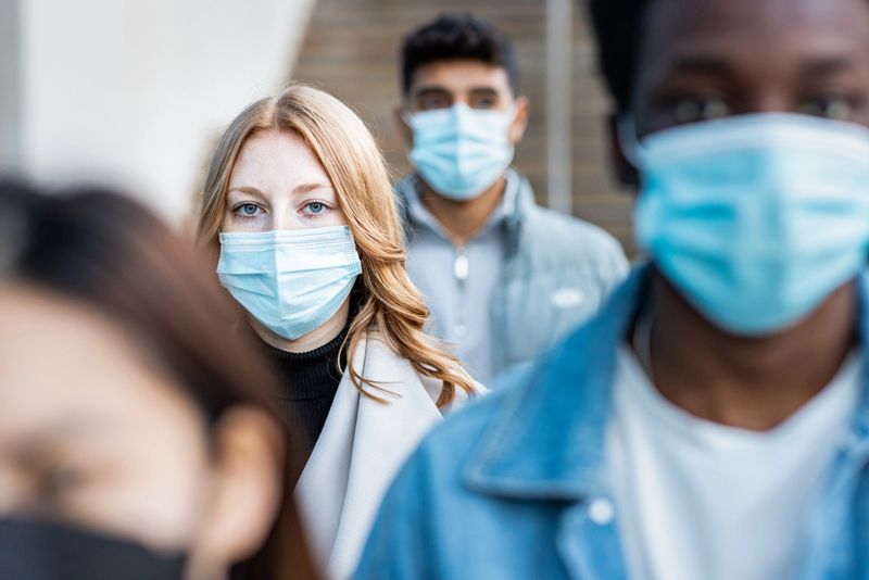Authentic shot of multiracial people in the city wearing face mask and walking on the pavement commuting to work - Lifestyle and health issues concepts