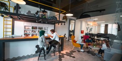 A modern office lounge with people collaborating and relaxing.