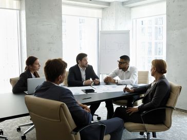 Small business team discussing cybersecurity strategies and IT security policies in a modern office setting