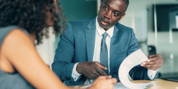 Homme d'affaires expliquant un document à une femme.