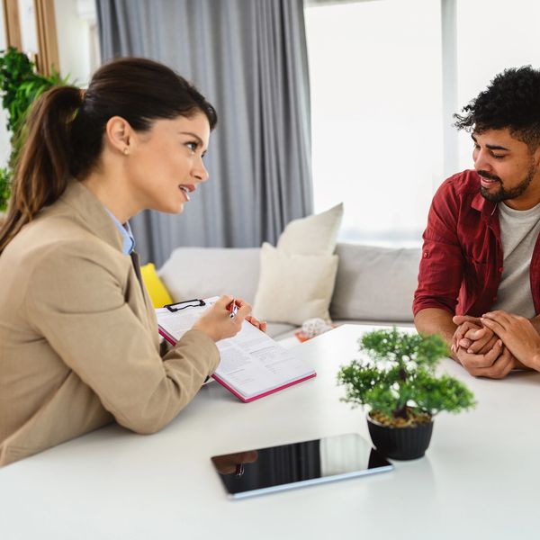 Therapist talking to a couple in a cozy room.
