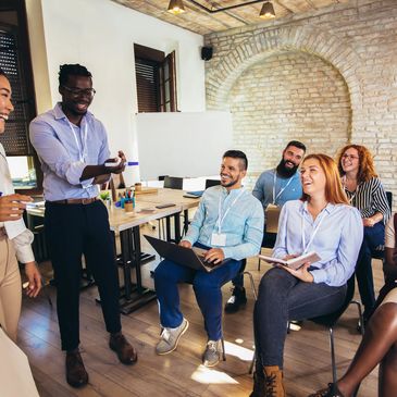 A group of people talking and smiling in a room together.
