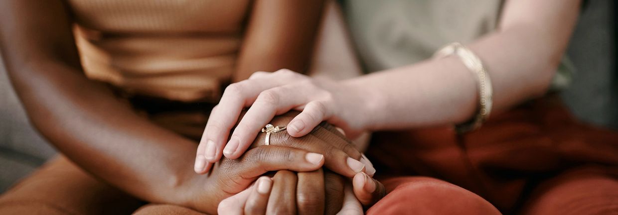 Two people holding hands, showing support and connection.