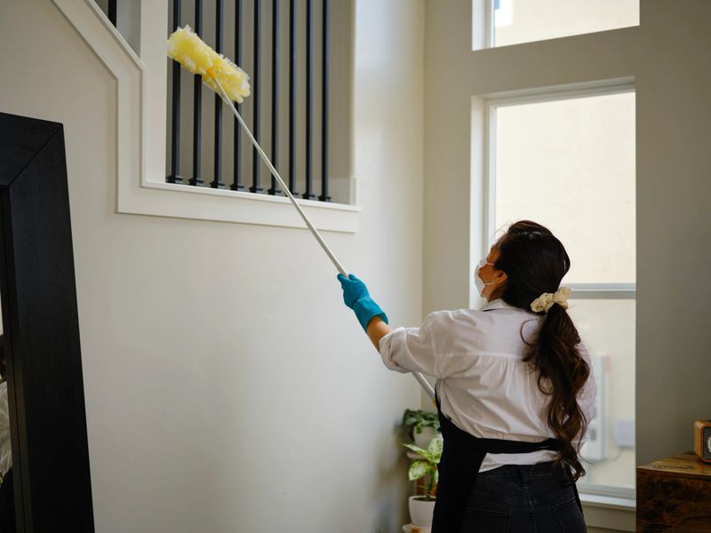 A professional housecleaner at work cleaning a home.