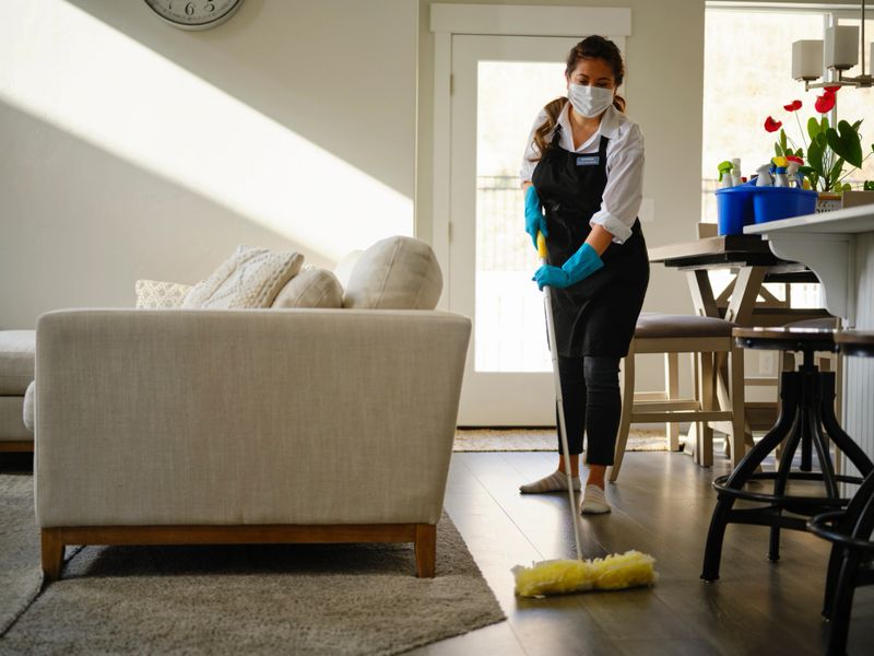 A professional housecleaner at work cleaning a home.
