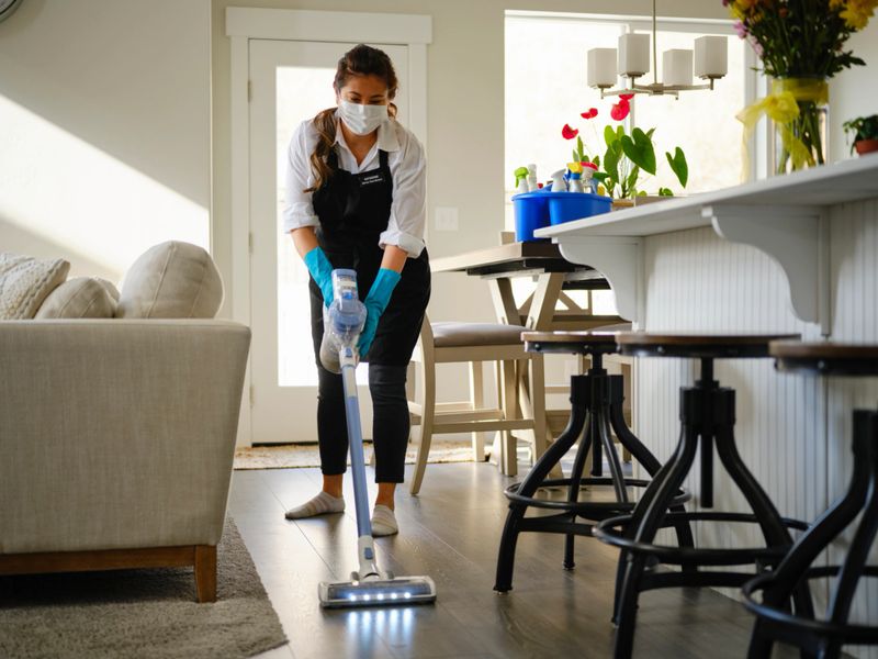 A professional housecleaner at work cleaning a home.
